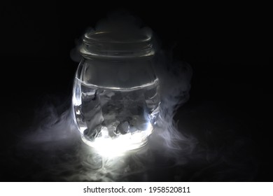 A Glass Jar Of Water Overflows With Steam From A Dry Ice Experiment. 