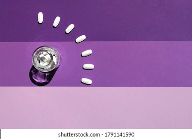 Glass Jar With White Pills On A Violet Paper Background With A Hard Shadow. Closeup, Top View.