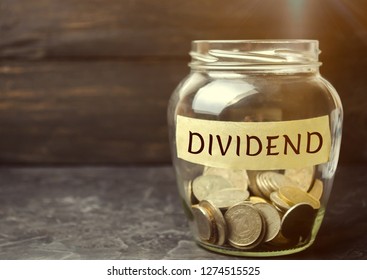 Glass Jar With The Word Dividend. A Dividend Is A Payment Made By A Corporation To Its Shareholders As A Distribution Of Profits. Concept Business Finance And Investment. Saving Money. Dividend Tax
