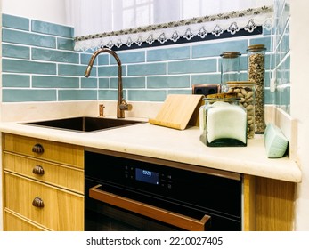 Glass Jars With Assorted Cooking Ingredients Placed On Kitchen Counter Near Sink And Built In Oven In Sunlit Kitchen At Home.