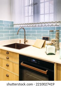 Glass Jars With Assorted Cooking Ingredients Placed On Kitchen Counter Near Sink And Built In Oven In Sunlit Kitchen At Home.