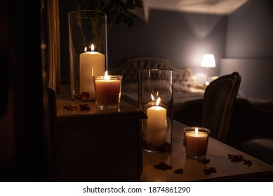 Glass Jar's With Burning Candles Light The Room, Making A Romantic And Warm Atmosphere In Retro Bedroom With Nice Decoration In Background.
