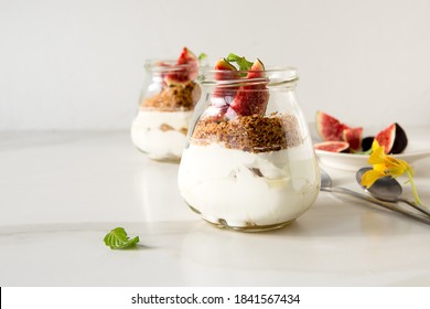 Glass Jars Of Fig Pudding On A Light Marble Table