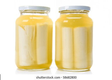 Glass jars with heart of palm on white .