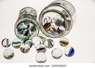 Glass Jars With Marbles Inside Or Falling Into The Jars, White Background