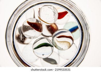 Glass Jars With Marbles Inside Or Falling Into The Jars, White Background