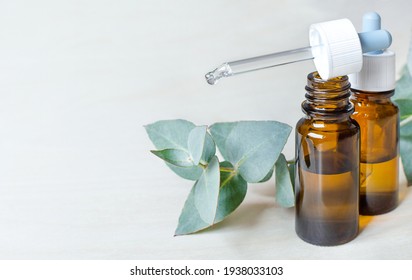 glass jars with nasal drops and a sprig of eucalyptus.