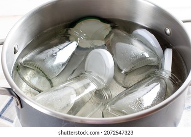 Glass jars sterilising in boiling water. Preparations for preservation. - Shutterstock ID 2072547323