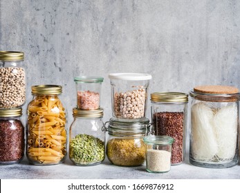 Glass jars with various cereals and seeds - peas split, sunflower and pumpkin seeds, beans, rice, pasta, oatmeal,  lentils,  bulgur on grey background  - Powered by Shutterstock