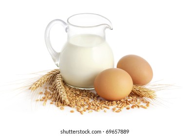 Glass Jug With Milk, Wheat Seeds And Two Eggs On White Background