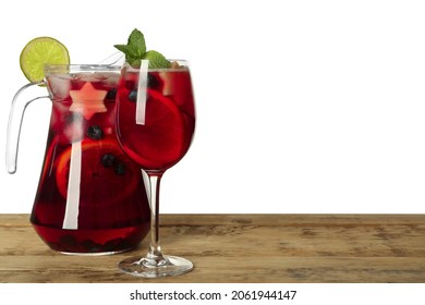 Glass and jug of Red Sangria on wooden table against white background. Space for text