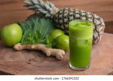 Glass Of Juice And Fresh Ingredients For Preparing Detox Green Juice, Kale Leaf, Ginger, Lemon, Mint, Pineapple And Green Apple On Wooden Texture And With Space For Writing