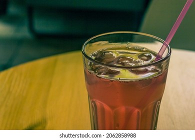 A Glass Of Juice With A Pipe On A Table Close Up