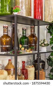 Glass large empty bottles and flasks, for wine and alcoholic beverages on a shelf in a shop window are sold on a shelf