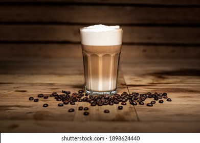 glass of latte macchiato coffee on brown background