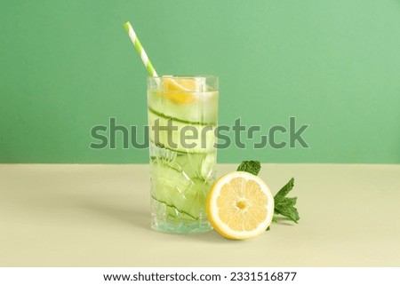 Glass of lemonade with cucumber and mint on colorful background