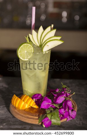 Glass of lemonade mojito cocktail in bar on bright blurred background 