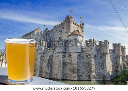 Glass of light beer against Castle of the Counts in Ghent, Belgium