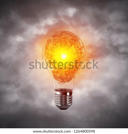 Glass lightbulb with multiple gears inside with grey cloudly skyscape on background. 3D rendering.