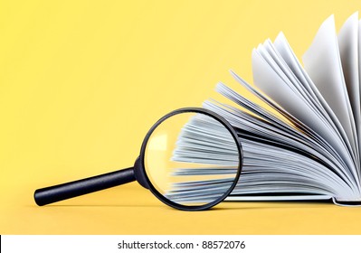 glass magnifying loupe and book on background - Powered by Shutterstock