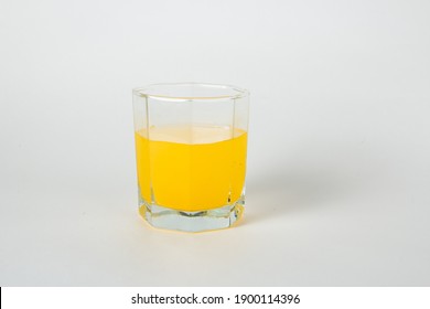A glass of mango juice. Transparent glass cup with orange liquid on a white background. Macro shooting - Shutterstock ID 1900114396