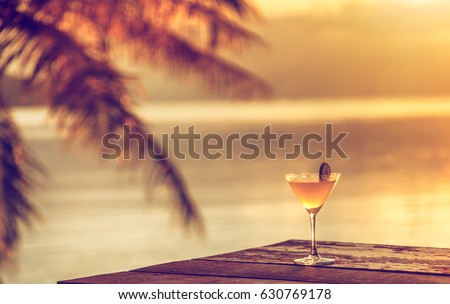 A glass of margarita cocktail on a beach cafe table on a tropical island