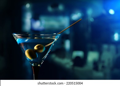 glass with martini , focus on a olives
