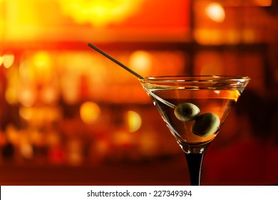 glass with martini , focus on a olives