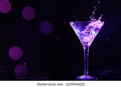 Glass of martini with ice and splashes in neon lights on dark background, bokeh effect. Space for text - Powered by Shutterstock