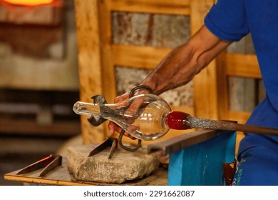 glass master while working in Murano furnace glass factory Venice Italy close up detail - Powered by Shutterstock