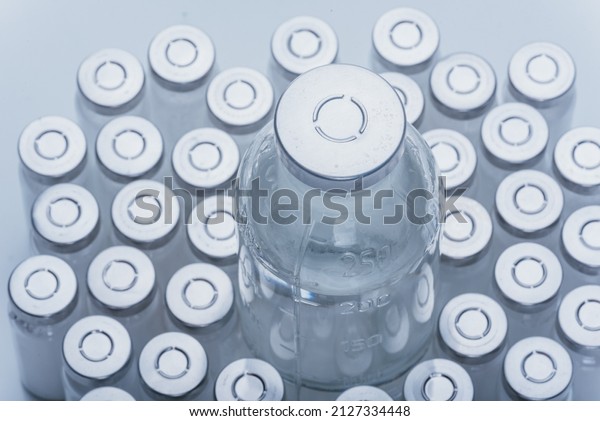 Glass medical ampoule vial for injection. Medicine\
is dry white drug penicillin powder or liquid with of aqueous\
solution in ampulla. Close up. Bottles ampule with aluminum cap on\
backgrounds gray.