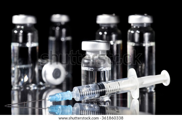 Glass\
Medicine Vials and Syringe on black\
background