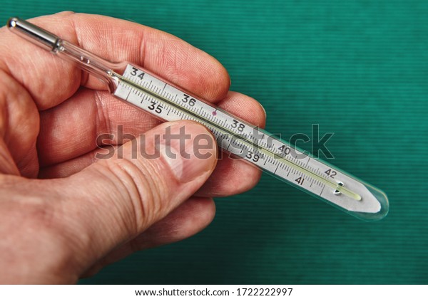 A glass mercury thermometer shows the\
high temperature of a persons body on its\
scale.