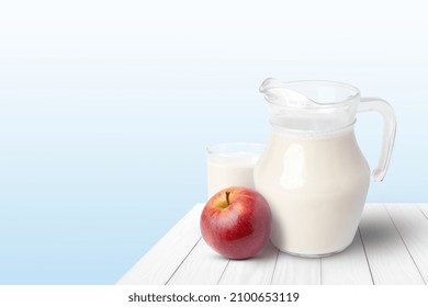 Glass Of Milk And Apple Fruit On Wooden Table With Blue Background.