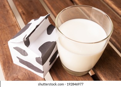 Glass Of Milk, A Carton Of Milk On Wooden Table.