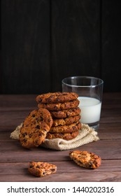 glass of milk chocolate cookies stack on wooden rustic table vertical orientation
