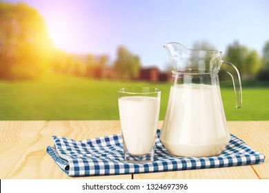 Glass of milk and jug on blurred background
