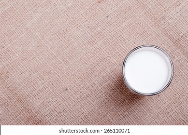 Glass Of Milk On Sackcloth, Top View, Space For Text