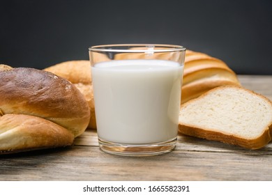 Glass Of Milk, Rolls, Sliced Loaf On A Wooden Background