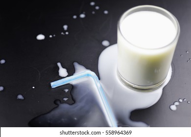 Glass Of Milk Splashing And Tube Straw On The Table