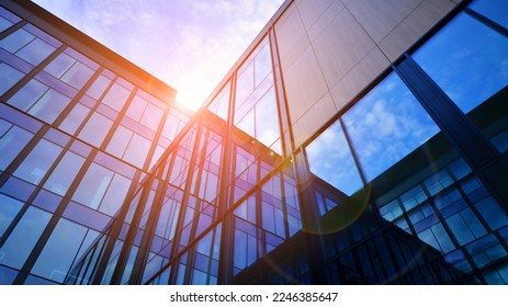 Glass modern building with blue sky background. Low angle view and architecture details. Urban abstract - windows of glass office building in  sunlight day. - Shutterstock ID 2246385647