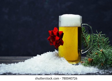 A Glass Mug Of Foaming Light Beer With A Gift Red Bow In The Snow And A Glass Mug Of Foaming Light Beer With A Gift Red Bow In The Snow And