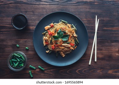 Glass noodles with chicken and vegetables.On a wooden background. The view from the top. copy space - Shutterstock ID 1695565894