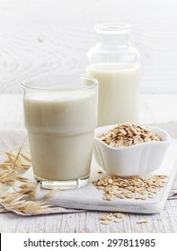 Glass Of Oat Milk On White Wooden Background