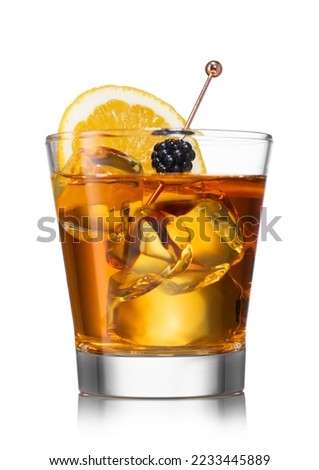 Glass of old fashioned cocktail with ice cubes and blackberry with orange on white. Whiskey,sugar,syrup and orange.