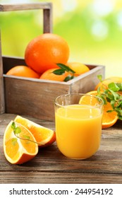 Zumo de naranja con crema de naranjas y rodajas sobre una mesa de madera y fondo luminoso