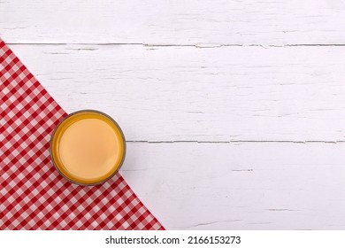 Glass Of Orange Juice On A Red Gingham Napkin On White Wooden Breakfast Table.  Flat Lay With Copy Space 