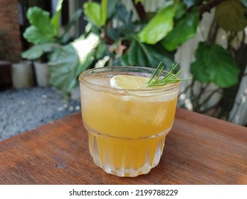 A Glass Of Orange Mocktail On The Wooden Table