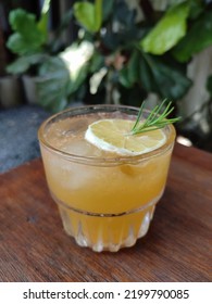 A Glass Of Orange Mocktail On The Wooden Table