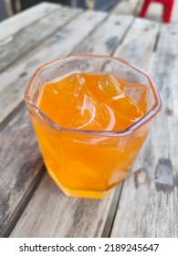 A Glass Of Orange Soda With Some Ice Cube. 